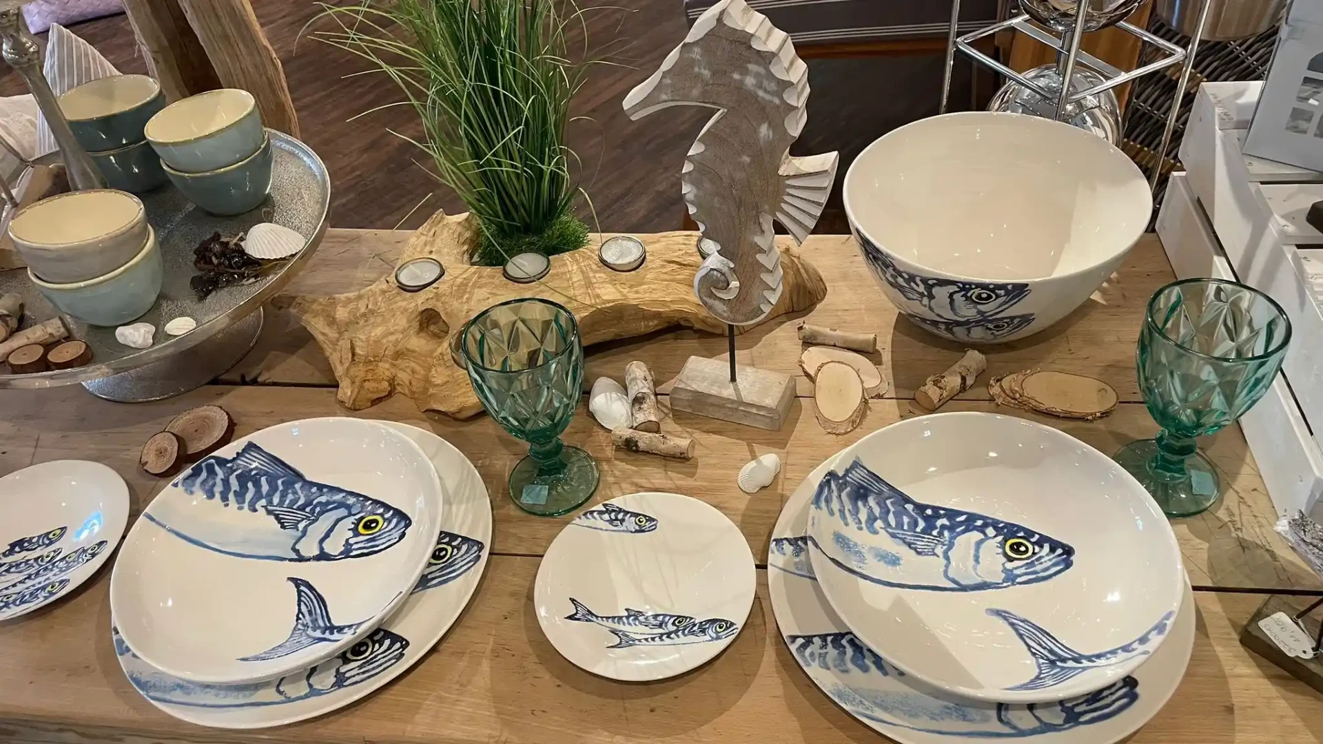 Maritimes Fischgeschirr in Blau-Weiß mit Glaskelchen und Treibholz-Deko auf Holztisch