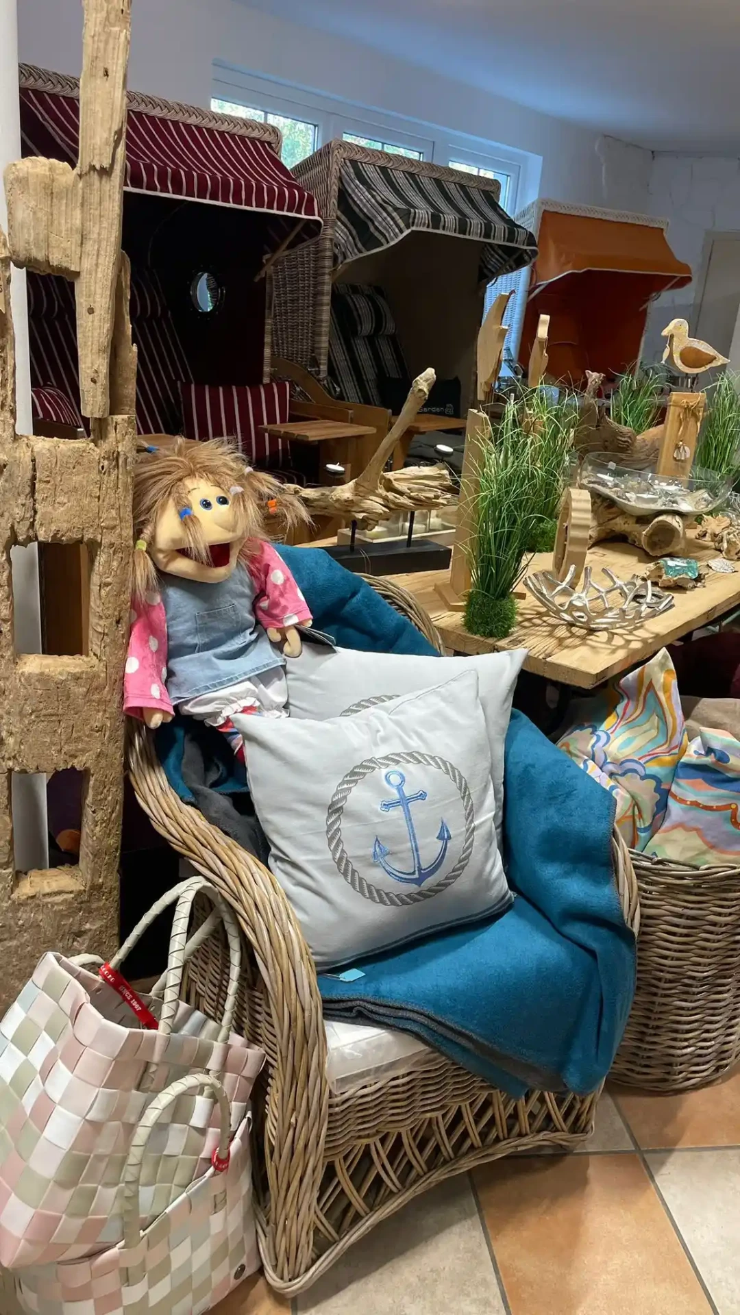 Korbsessel mit Anker-Kissen, petrolfarbener Wolldecke und Handpuppe
